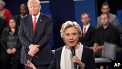 Kandidat presiden AS dari Partai Demokrat Hillary Clinton berbicara dalam debat kepresidenan disaksikan oleh lawannya dari Partai Republik, Donald Trump, di Washington University, St. Louis (9/10). 