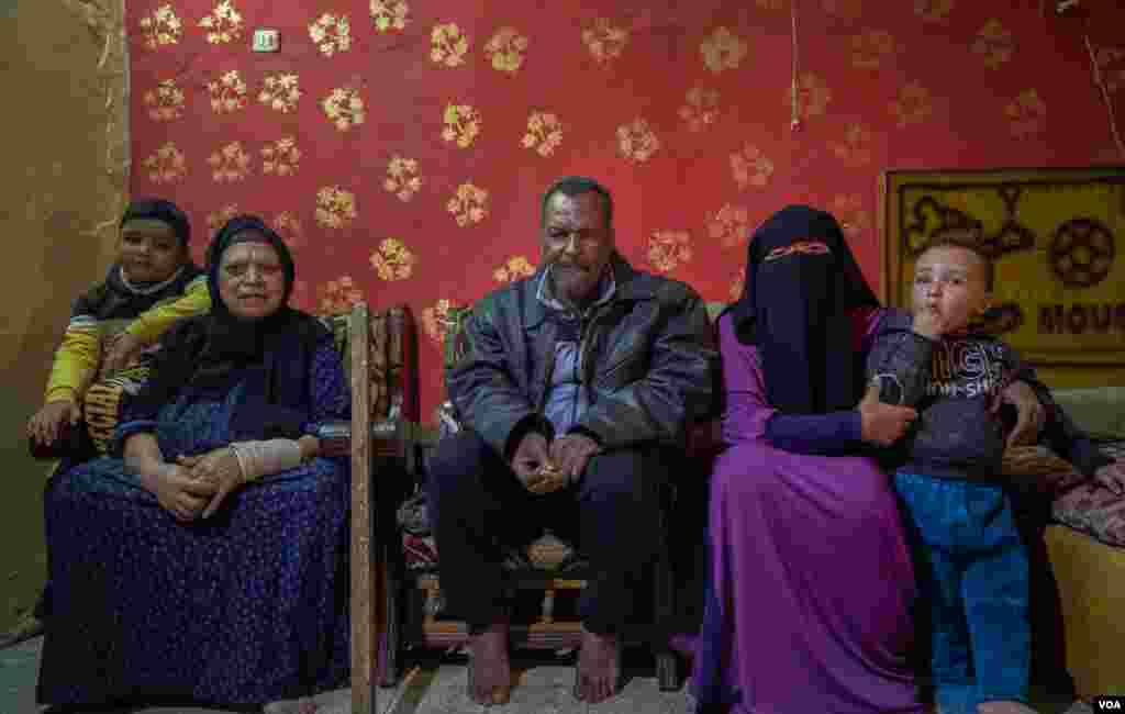 Abdallah lives with his wife (L), daughter (R), and grandsons. "We share the same space with my other two siblings when they bring their families to visit and spend some days with us," he says. (Hamada Elrasam/VOA)