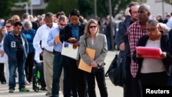 FILE - People wait in line to enter the Nassau County Mega Job Fair at Nassau Veterans Memorial Coliseum in Uniondale, N.Y., Oct. 7, 2014. 