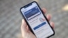 Seseorang memegang smartphone dengan 'Corona Warn-App' (Aplikasi Peringatan Korona) di Berlin, Jerman, Senin, 15 Juni 2020. (AP Photo / Michael Sohn)