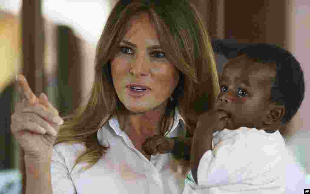 First lady Melania Trump holds a baby as she visits the Nest Orphanage in Limuru, Kenya, Oct. 5, 2018.