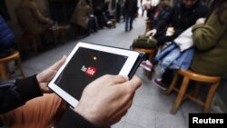 Seorang pria mencoba menonton YouTube dari tabletnya di sebuah kafe di Istanbul (27/3).
