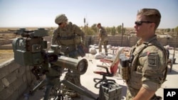 FILE - In this Aug. 20, 2017, file photo, U.S. Army soldiers stand next to a guided-missile launcher, a few miles from the front line, in the village of Abu Ghaddur, east of Tal Afar, Iraq. 