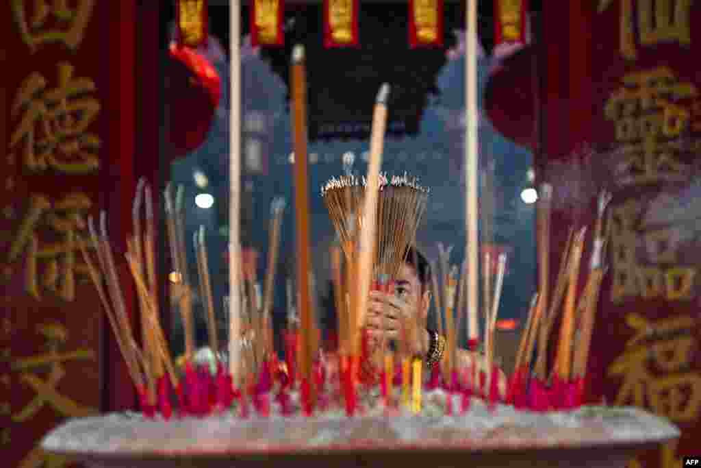 An ethnic Malaysian Chinese man burns incense as he offers prayers on the first day of the Lunar New Year of the Snake at Kwong Fook Temple in Bentong, Malaysia's Pahang state.