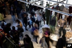 FILE - People shop at a retail store on Black Friday, Nov. 25, 2022, in New York.