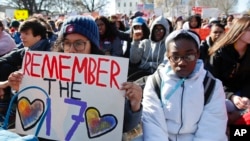 FILE - Students sit in silence as they rally in front of the White House in Washington, March 14, 2018.