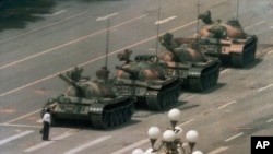 FILE - A Chinese man stands alone to block a line of tanks heading east on Beijing's Cangan Boulevard in Tiananmen Square, in early June 1989. 