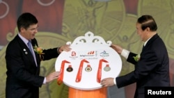 Wakil ketua Komite Olimpiade Beijing (BOCOG) Jiang Xiaoyu (kanan) menerima medali dari Pemimpin BHP Billiton China Clinton Dines dalam upacara serah terima di Beijing, 2 Juli 2008 (Foto: dok). BHP Biliton membantah laporan surat kabar Australia, Financial Review yang menuduh perusahaannya melanggar undang-undang anti-korupsi saat menjadi sponsor Olimpiade ini (13/3).