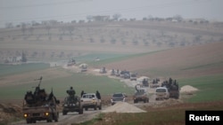 FILE - Members of al-Qaida's Nusra Front drive in a convoy as they tour villages in the southern countryside of Idlib, Syria.