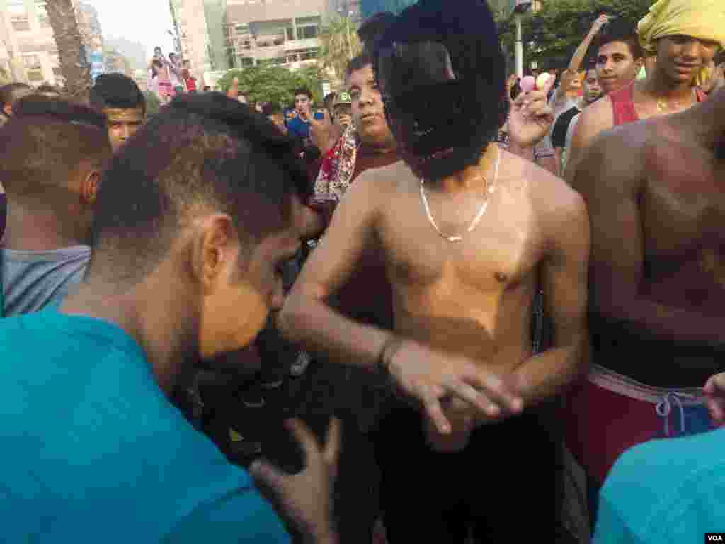 A young Egyptian man wearing a gorilla mask does the “Shaby” dance after Friday prayers, as a DJ starts the party, in Cairo, Egypt, July 6, 2016. (Photo: Hamada Elrasam for VOA)