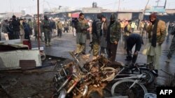 Petugas keamanan Pakistan memeriksa lokasi ledakan bom di Peshawar (19/1).