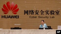 FILE - A receptionist stands at the front counter of the Huawei's Cyber Security Lab at the Huawei factory in Dongguan, China's Guangdong province, March 6, 2019. 