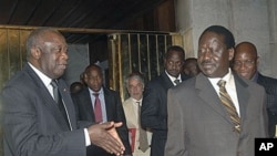 Ivory Coast strongman Laurent Gbagbo, left, talks with Kenyan Prime Minister Raila Odinga, an African Union envoy sent to mediate the ongoing Ivorian political standoff, following a meeting at the presidential palace in Abidjan, Ivory Coast, Jan 17, 2011