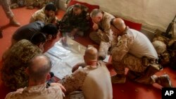 Tentara AS bersama tentara nasional Afghanistan membahas rencana serangan terhadap pemberontak Taliban di kamp Hanson, Afghanistan (13/6). 