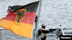 FILE - A gunner stands in position aboard a German Navy frigate during exercises in the Baltic Sea, near Rostock, Germany, Sept. 11, 2019.