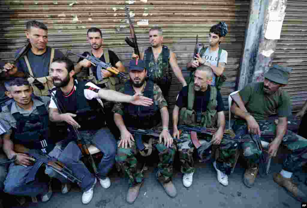 Sunni gunmen sit on a street where clashes erupted between supporters and opponents of the Syrian regime in Tripoli, Lebanon, Aug. 22, 2012.