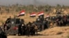 Smoke billows on the horizon as Iraqi military forces prepare for an offensive into Fallujah to retake the city from Islamic State militants in Iraq, May 30, 2016. 