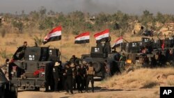 Smoke billows on the horizon as Iraqi military forces prepare for an offensive into Fallujah to retake the city from Islamic State militants in Iraq, May 30, 2016. 