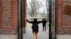 FILE - A student carries a box to her dorm at Harvard University, after the school said it would move to virtual instruction for graduate and undergraduate classes, in Cambridge, Massachusetts, March 10, 2020. 