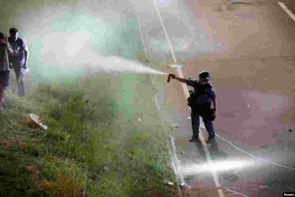 A police officer uses pepper spray as people gather on Interstate 94 to protest the fatal shooting of Philando Castile by Minneapolis area police during a traffic stop, in St. Paul, Minnesota, July 9, 2016.