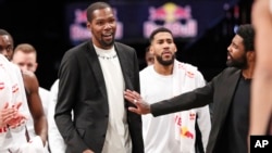 NBA player Kevin Durant who smiles as he stands to greet teammates returning to the bench during a timeout in the second half of an NBA basketball game against the New York Knicks, Dec. 26, 2019.