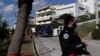 A police truck carries the car of a veteran Greek crime reporter in southern Athens, April 9, 2021. Giorgos Karaivaz was gunned down Friday near his home, police said.
