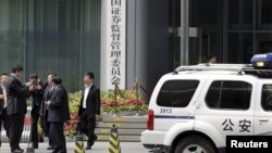 FILE - A police vehicle is seen parked outside a building in Beijing, July 9, 2015.