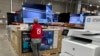 An associate checks over a big-screen television on display in a Costco warehouse Feb. 6, 2024, in Colorado Springs, Colorado. The U.S. Labor Department reported on Feb. 13 that the consumer price index rose 0.3% from December to January.