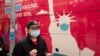 Seorang pria membawa kartu vaksinasi setelah menerima vaksin Covid-19 Johnson & Johnson, Rabu 7 April 2021, di Sunset Park, New York. (Foto: AP)