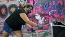 Luciana Holanda smashes a computer monitor at the Rage Room, a place where people can destroy everyday objects to vent their anger, in Sao Paulo, Brazil, Feb. 19, 2021.
