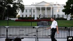 Seorang petugas Secret Service bersama anjing pelacak melakukan patroli di luar komplek Gedung Putih, Senin (22/9).