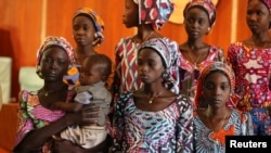 FILE - One of the 21 Chibok school girls recently released by Boko Haram carries her baby during their visit to meet President Muhammadu Buhari In Abuja, Nigeria, Oct. 19, 2016. 