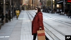 Seorang wanita melintasi jalan yang biasanya ramai di Sydney, Rabu, 7 Juli 2021. (Foto: AP)
