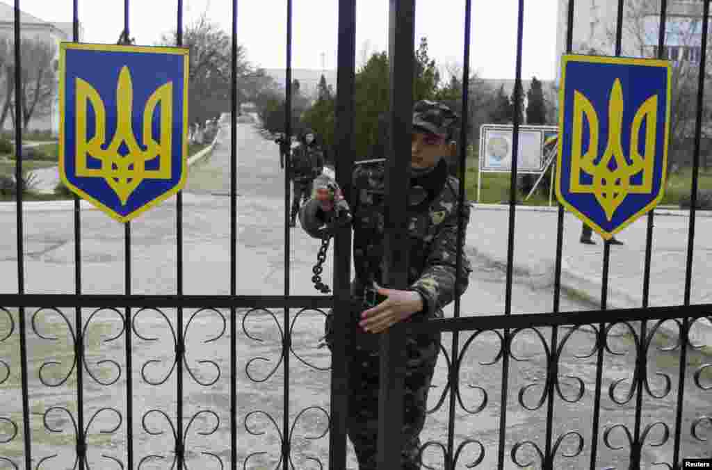Seorang prajurit Ukraina menutup pintu masuk di pangkalan udara militer di kota Krimea, Belbek, 20 Maret 2014.