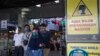 Para pengunjung yang mengenakan masker dan pelindung wajah untuk mencegah penularan Covid-19, keluar dari sebuah pusat perbelanjaan di Surabaya, 3 Juni 2020. (Foto: AFP)