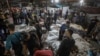EDITORS NOTE: Graphic content / People gather around bodies of Palestinians killed in a strike on the Ahli Arab hospital in central Gaza after they were transported to Al-Shifa hospital, on October 17, 2023.