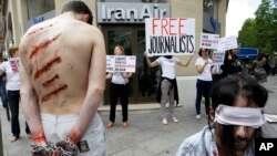 Para aktivis Wartawan Tanpa Tapal Batas berperan sebagai korban dalam unjuk rasa di luar kantor maskapai penerbangan Iran Air di Champs Elysée di Paris, 10 Juli 2012, untuk memprotes penahanan para wartawan Iran.
