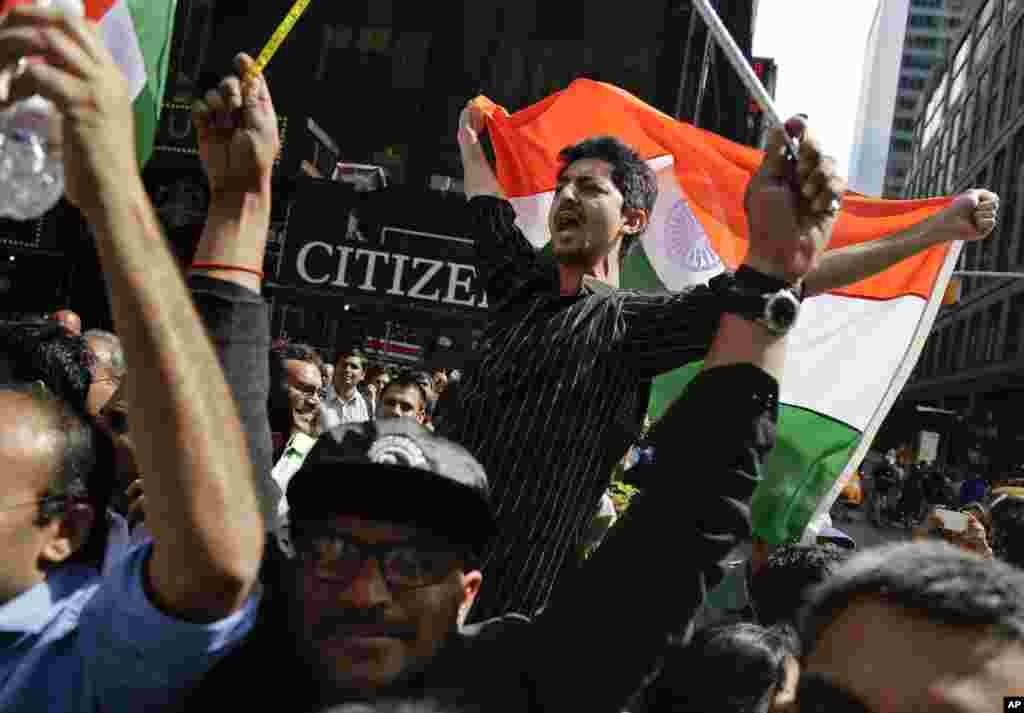 Supporters of Indian Prime Minister Narendra Modi shout slogans as they watch a live stream of Modi's speech from Madison Square Garden, New York, Sept. 28, 2014.