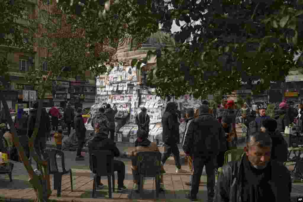 Syrians look at photos of people reported to be missing, by members of ousted President Bashar al-Assad's army or a pro-government militia, at the Marjeh square in Damascus.