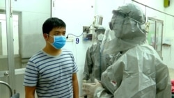 FILE - Vietnam's Vice Minister of Health Nguyen Truong Son, right, talks with a man in an isolated section of a hospital where two Chinese citizens had tested positive for coronavirus, in Ho Chi Minh city, Vietnam, Jan. 23, 2020.
