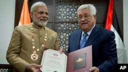 Presiden Palestina Mahmoud Abbas, kanan, memberikan medali kehormatan kepada Perdana Menteri India Narendra Modi dalam kunjungan ke market Otoritas Palestinian di Ramallah, kota di Jalur Barat, 10 Februari 2018.