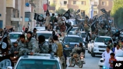 FILE - Fighters from the Islamic State group parade in Raqqa, north Syria, June 30, 2014. Islamic State militants are cracking down on the few remaining Christians and preventing them from leaving Raqqa, Syria, local activists told VOA on April 5, 2016.