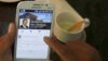 FILE - A person uses a smartphone to look at the Facebook page of Cambodia's Prime Minister Hun Sen, in central Phnom Penh, Cambodia Oct. 7, 2015. Cambodia's Prime Minister Hun Sen is taking a belated leap into the digital age.