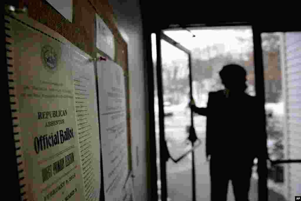 Surat suara pemilihan pendahuluan New Hampshire dipasang di dinding sementara para pemilih memasuki TPS, 9 Februari 2016, di Nashua, N.H.