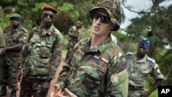 U.S. Army special forces Captain Gregory, 29, from Texas, center, who would only give his first name in accordance with special forces security guidelines, speaks with troops from the Central African Republic and Uganda, in Obo, Central African Republic,