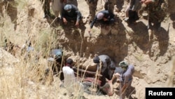 Para penduduk desa mengumpulkan jenazah penduduk sipil yang dibunuh oleh kaum pemberontak di desa Mirza Olang, di provinsi Sar-e Pul, Afghanistan, 15 Agustus 2017. (Foto:dok)