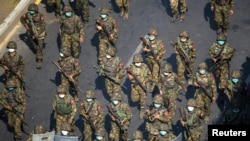 Tentara Myanmar berjalan di sepanjang jalan selama protes terhadap kudeta militer di Yangon, Myanmar, 28 Februari 2021. (Foto: Reuters)