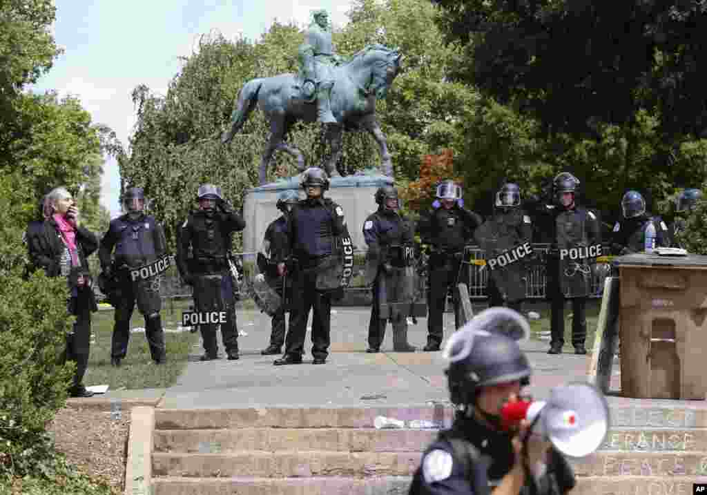 State Police in riot gear guard Lee Park after a white nationalist demonstration was declared illegal and the park was cleared in Charlottesville, Va., Aug. 12, 2017. Hundreds of people chanted, threw punches, hurled water bottles and unleashed chemical