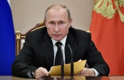 FILE - Russian President Vladimir Putin speaks at a meeting with members of the Security Council in the Kremlin in Moscow, Aug. 23, 2019.