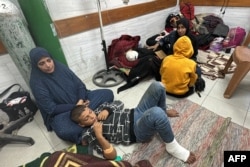 FILE - Perempuan dan anak-anak menunggu perawatan medis saat mereka duduk di lantai bangsal trauma di Rumah Sakit Kamal Adwan di Beit Lahia, Jalur Gaza utara, 24 Oktober 2024. (AFP)